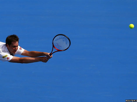 Germany's Florian Mayer misses a shot against Australia's Bernard Tomic during the Sydney International tennis tournament
