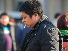 北京街头一名男子叼着香烟走过（7/1/2011）