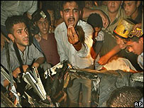 Palestinos em volta do carro em que estavam os membros do Jihad Islâmico