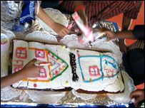 他们正在用附近建筑的图片装饰一个蛋糕。