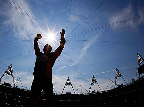 Australia's Russell Short stands silhouetted against the sun during the Men's shot put final at the Olympic Stadium.