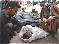 عزاداران بر سر جسد کودک پس از انفجار کربلا