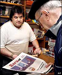 Dois homens passam ao lado de grafite do ETA