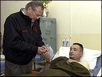 Donald Rumsfeld yaralı bir askeri ziyaret ediyor
