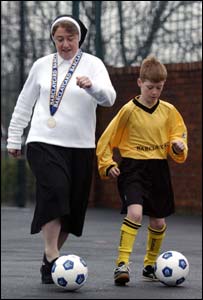 سسٹر میتھیو ایک بچے کو فٹبال کے گُر سکھاتے ہوئے