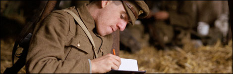 Soldier in a World War I uniform, writing in a book