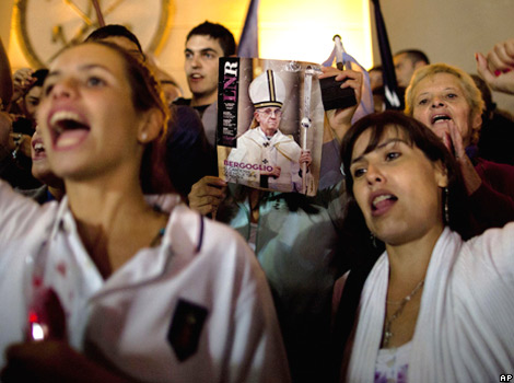 Worshippers hold the front page of a magazine showing a photograph of the new pope, Francis I, during the celebrations in Buenos Aires