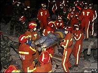 Executivo Ma Yuanjiang sendo retirado do prédio de dois andares pelas equipes de resgate