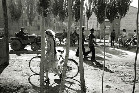 Woman pushing a bicycle, photo by Tom Ang