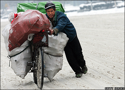 Một người đàn ông đang cố đẩy chiếc xe đạp của mình ở Vũ Hán, ngày 27/01/ 2008