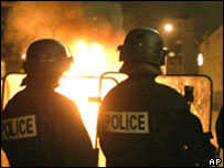 Policiais franceses observam veículo a que manifestantes atearam fogo em Montfermeil, no norte de Paris