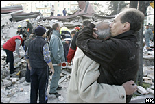 2 men hug amidst the debris