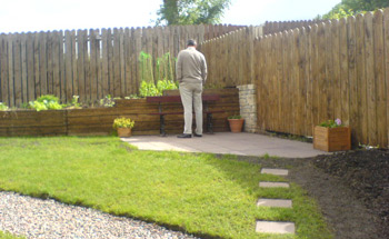 John inspects the veg bed from the new patio area.