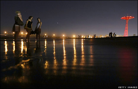 Những người phụ nữ đứng cạnh bờ biển trong khu giải trí Astroland ở New York trong đêm cuối trước khi khu này đóng cửa.