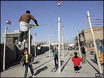 Crianças brincam em balanços num bairro na área central de Bagdá