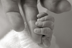 father and baby hold hands