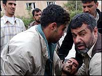 Bağdat'ta bir patlama sonrası yaralı bir kişiyi hastaneye götürmeye çalışanlar