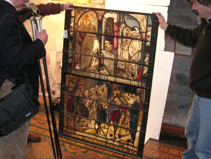Three men ponder over a panel that has been removed
