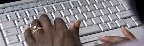 Hands typing on a computer keyboard