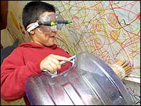 boy with pens on goggles and barrel of pencils