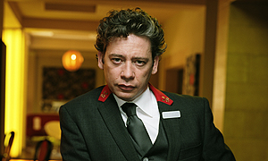 Dexter Fletcher plays Tony Casemore, Concierge