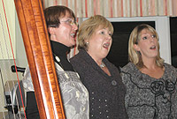 Triawd Caeran yn canu'r cywydd croeso, ysgrifennwyd gan Berwyn Roberts, yn ystod y noson