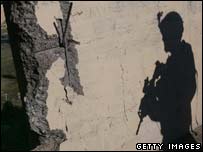 Sombra de soldado americano projetada em uma parede em Bagdá