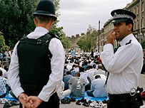 Police officers watch Muslims praying outside Finsbury Park Mosque. Getty Images