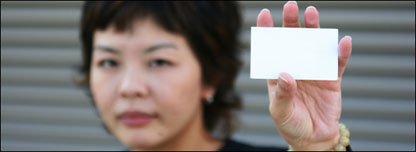 A girl holding a blank namecard