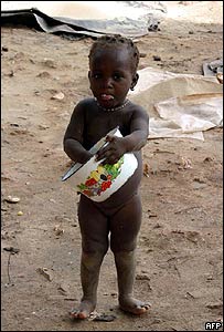 دختربچه خردسالی در مالی، دانه های برنج را از کف يک ظرف می خراشد