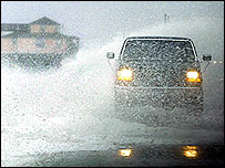 Homem anda contra ventos fortes no Estado da Carolina do Norte