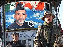 Hamid Karzai afişi önünde asker