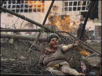 Một người phụ nữ giúp hàng xóm bị thương trong một vụ không kích của Nga ở Gori