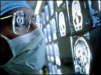 Surgeon looking at brain scans on x-ray film