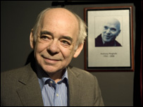 Alan Plater standing in front of a photograph of Anthony Minghella
