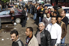 A long queue of men waiting to vote