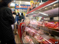 Mulher faz compras num açougue em Tóquio