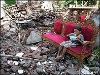 Menino em frente à sua casa destruída pelo terremoto