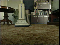 Mulher passando aspirador de pó