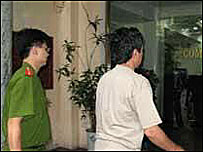 Cảnh sát áp giải phó tổng giám đốc Đỗ Hữu Dũng, ảnh của VietnamNet