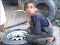 يو ماشوم چې له خپل قد او عمر څخه دروند کار کوي.