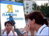 Українка робить гримасу до біг-борда Партії Регіонів (фото УНІАН)