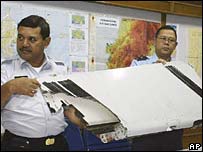 Membros de equipe de resgate mostram pedaço de avião encontrado na Indonésia