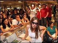 Passageiros ouvem explicações de funcionários de empresas aéreas no aeroporto de Buenos Aires