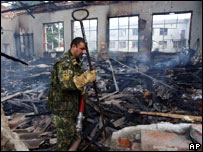 Membro de equipe de resgate anda sobre escombros de escola em Beslan após o fim do cerco