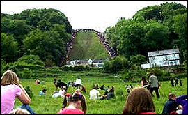 Crowds watch competitors  in the cheese-rolling competition