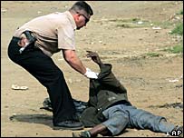 Policial examina corpo na rua em Johanesburgo