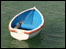 Small blue and white dinghy afloat.