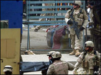 Soldados americanos carregam corpo com cadáver em Bagdá