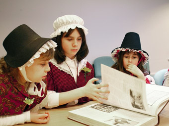 Disgyblion Ysgol Gynradd Dihewyd, Ceredigion yn mwynhau darllen llyfr yn y Llyfrgell Genedlaethol Cymru, Aberstwyth wrth ddathlu Dydd Gwyl Dewi a Diwrnod y Llyfr.